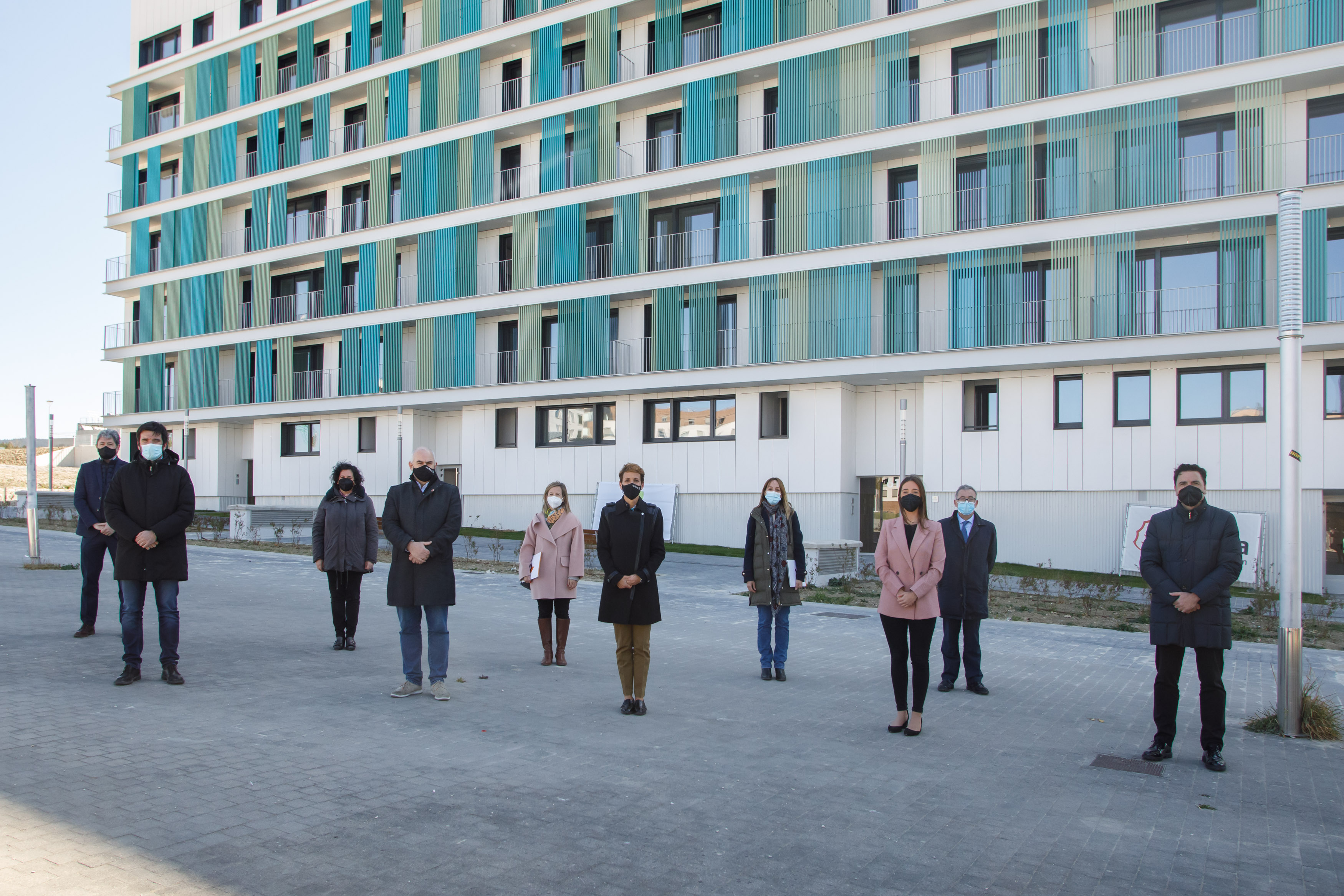 Fotografía exterior de diez personas delante de un edificio.