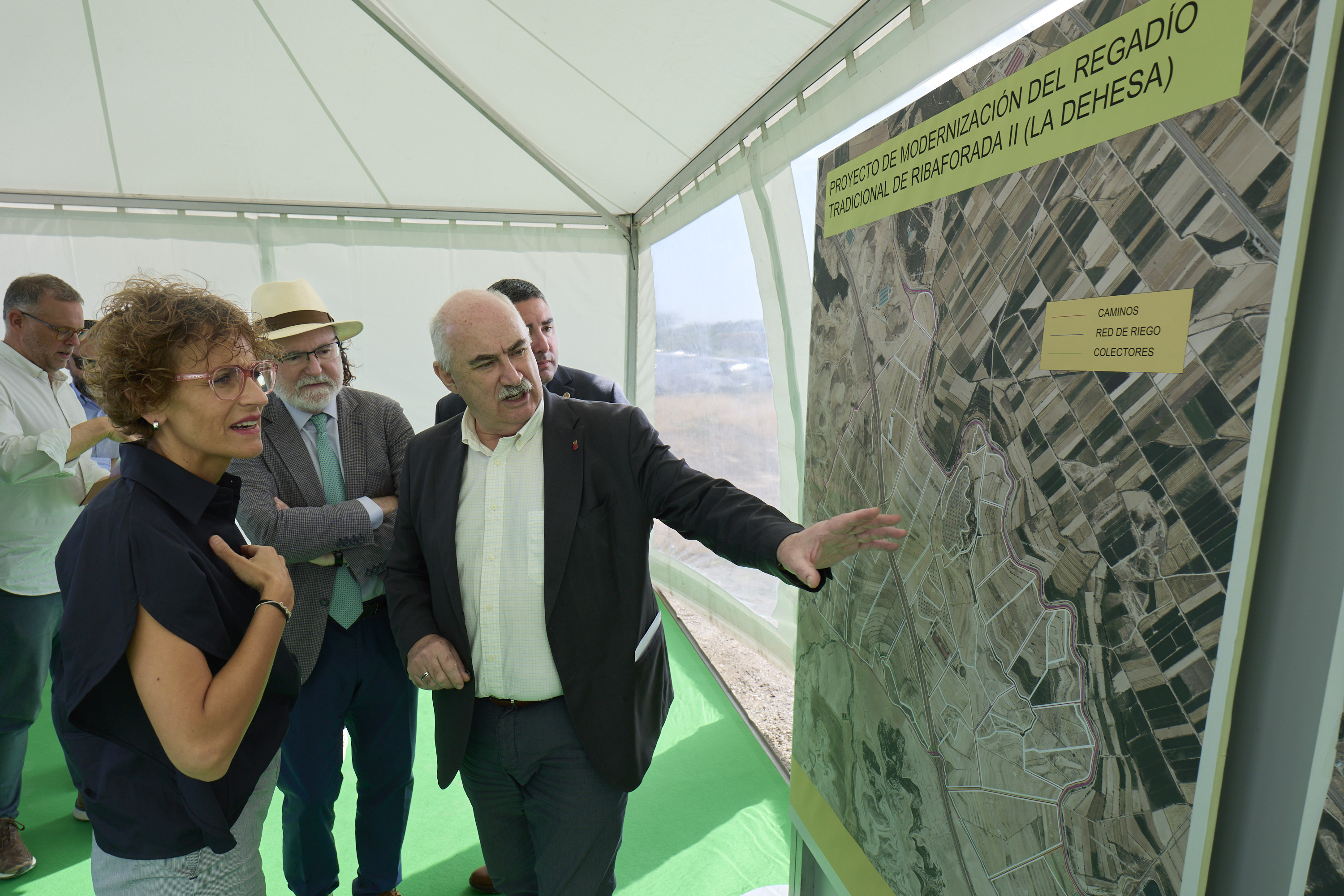Dos personas mirando e interpretando un cartel con un mapa 