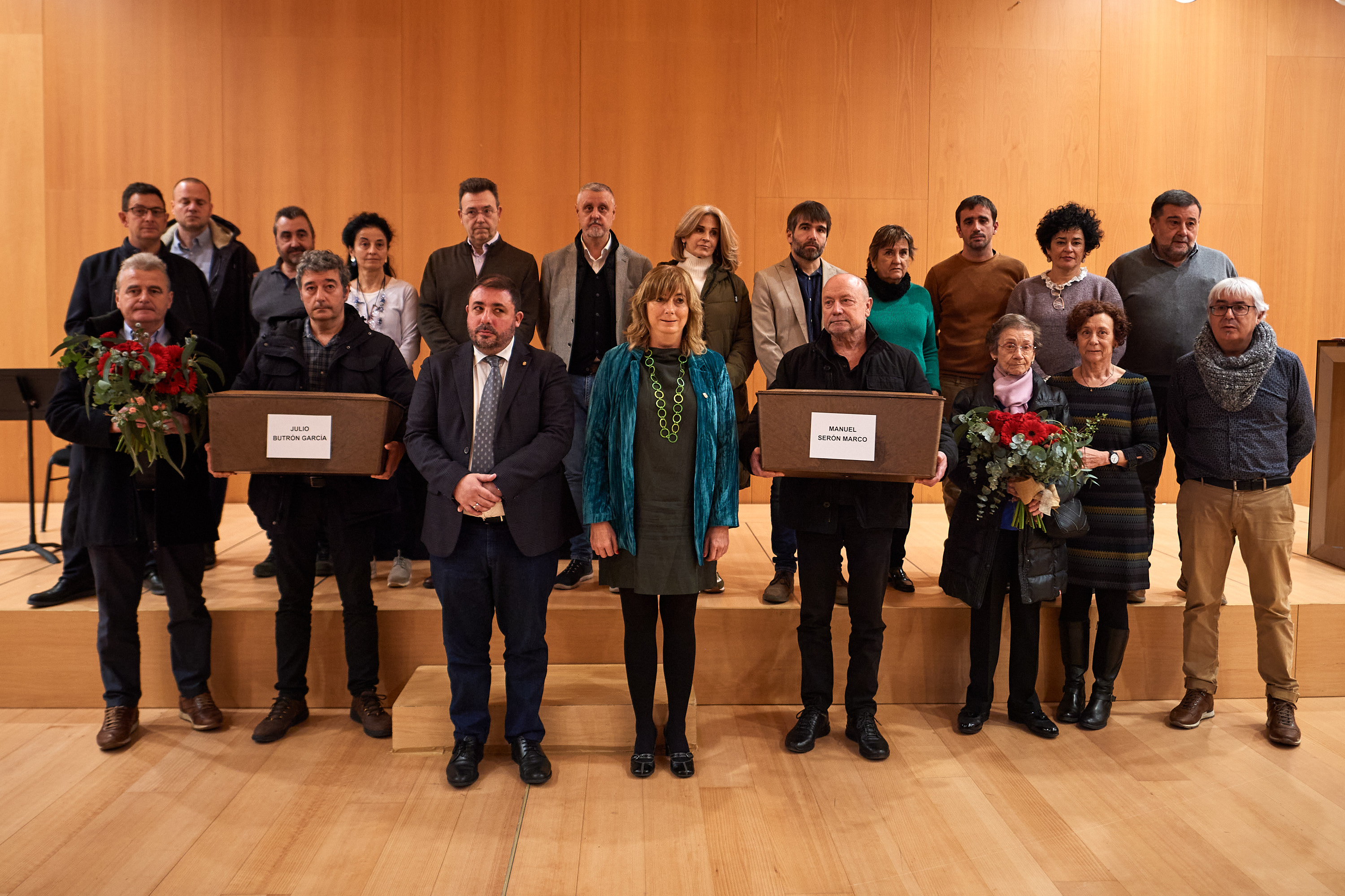 Fotografía de la consejera Ana Ollo, en el centro, junto al Presidente del Parlamento, Unai Uhalde, y familiares de Julio Butrón García y Manuel Serón Marco.