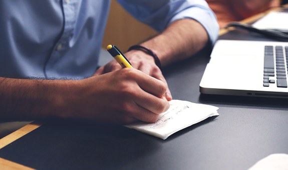 Fotografía de una persona escribiendo en una libreta