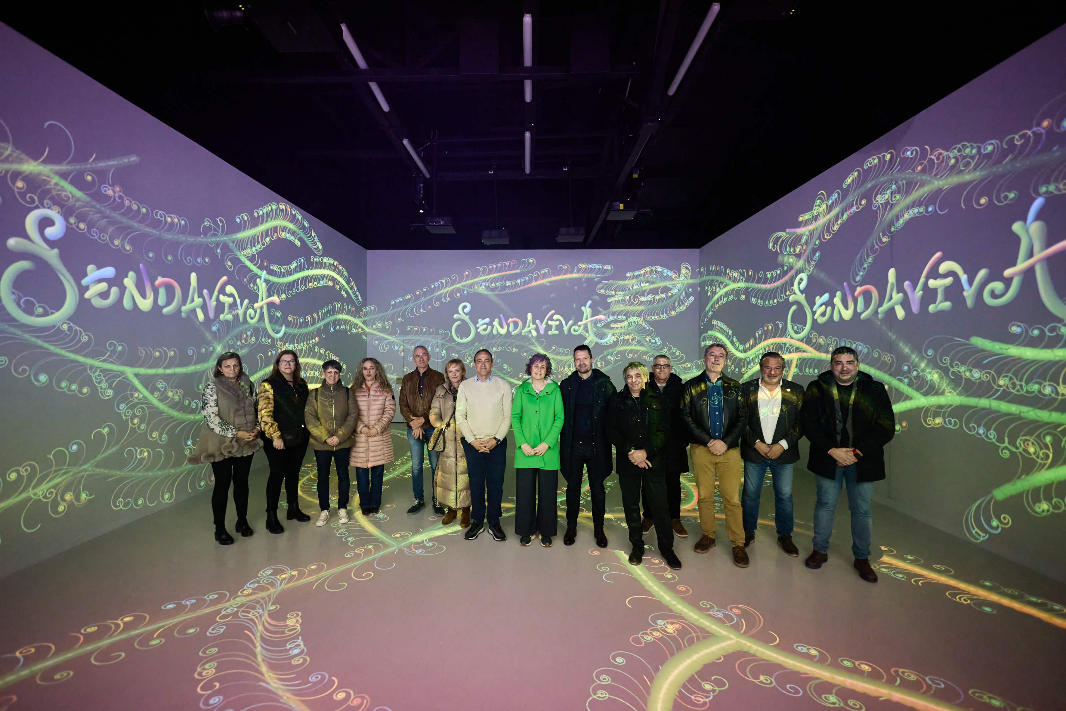 Grupo de personas en una sala ambientada con el logo de Sendaviva