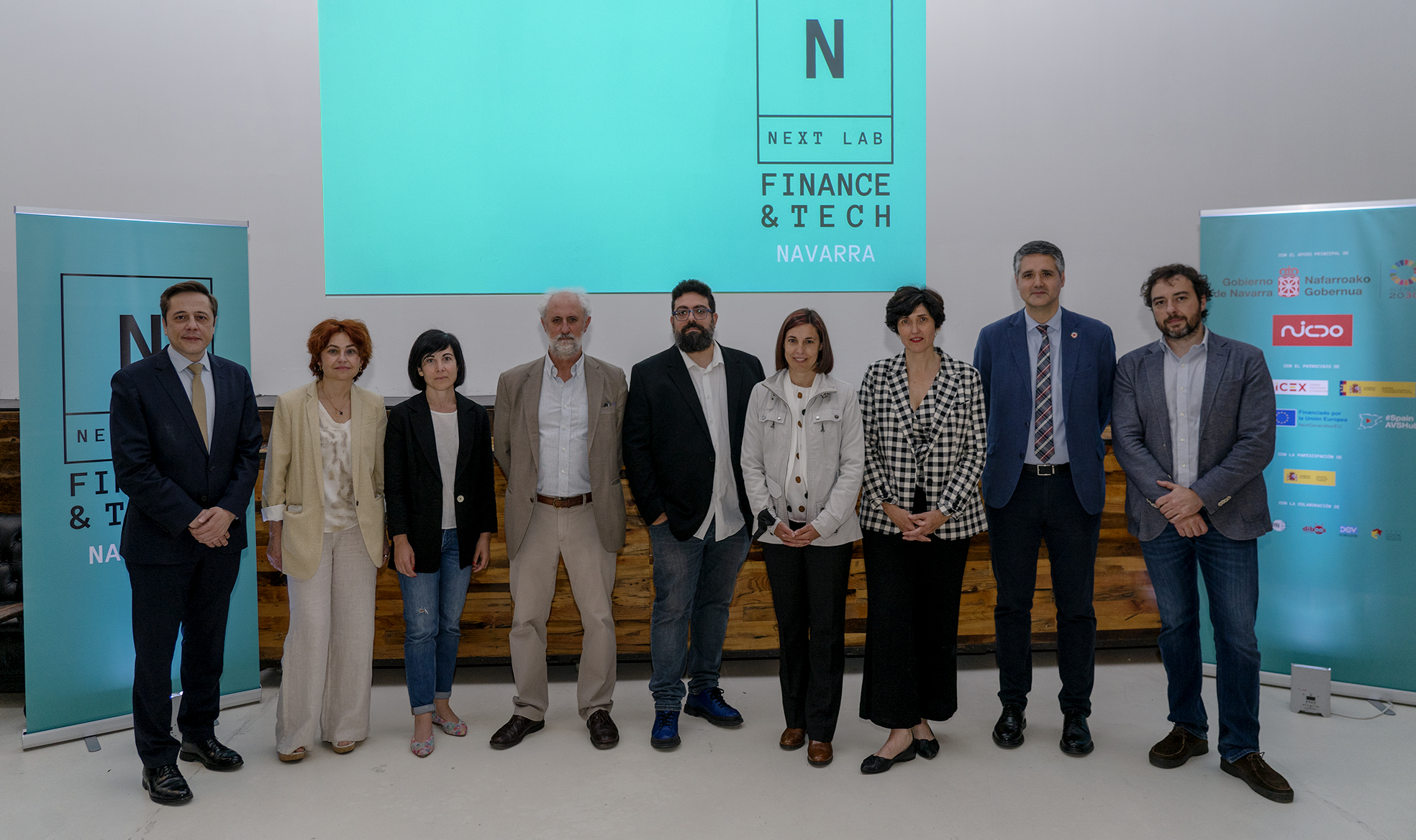 Fotografía de varias personas de pie durante la presentación del evento.