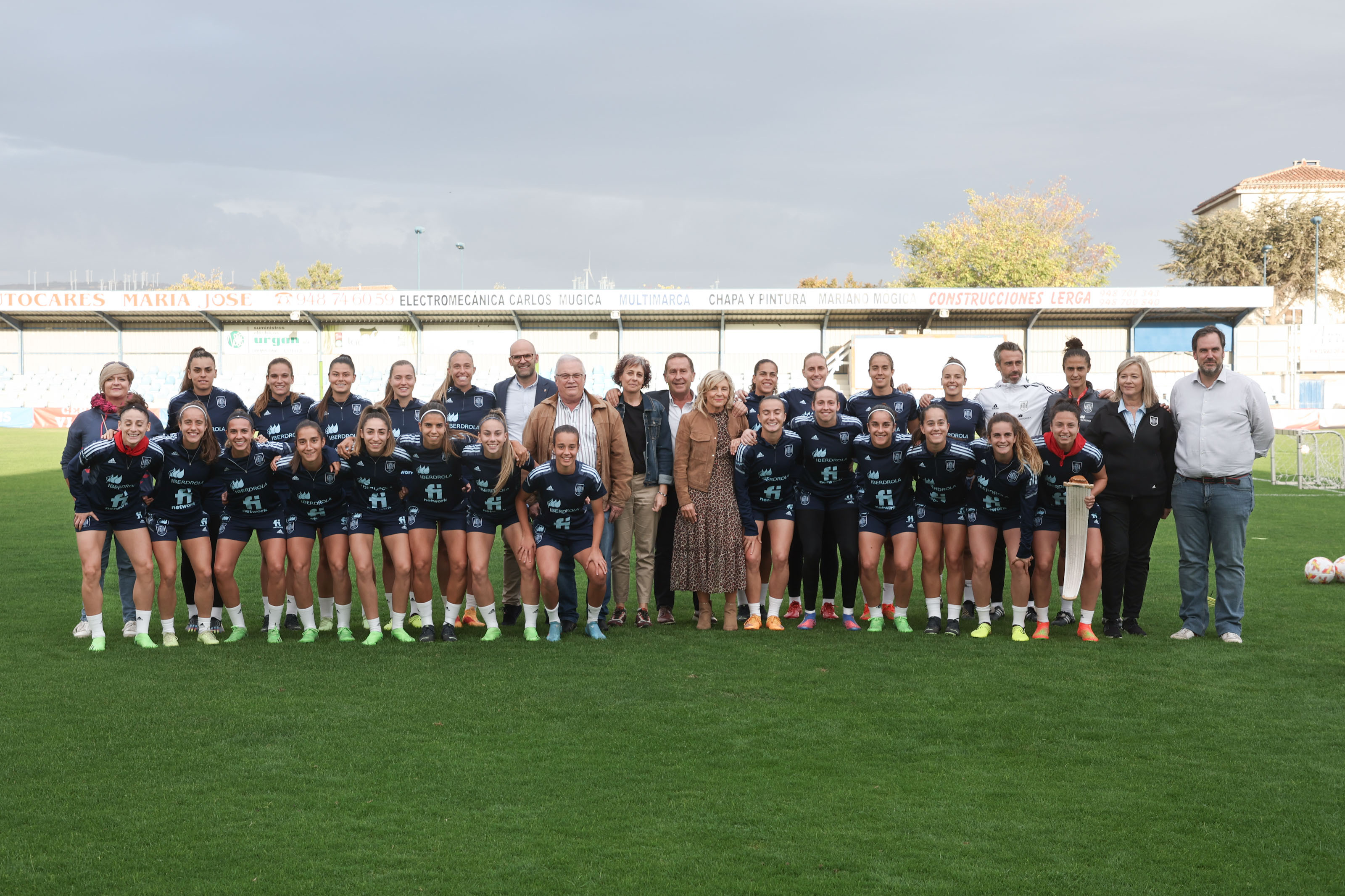 Fotografía de la selección española junto con el equipo de representantes navarros encabezado por la consejera Esnaola, en el campo San Francisco de Tafalla.
