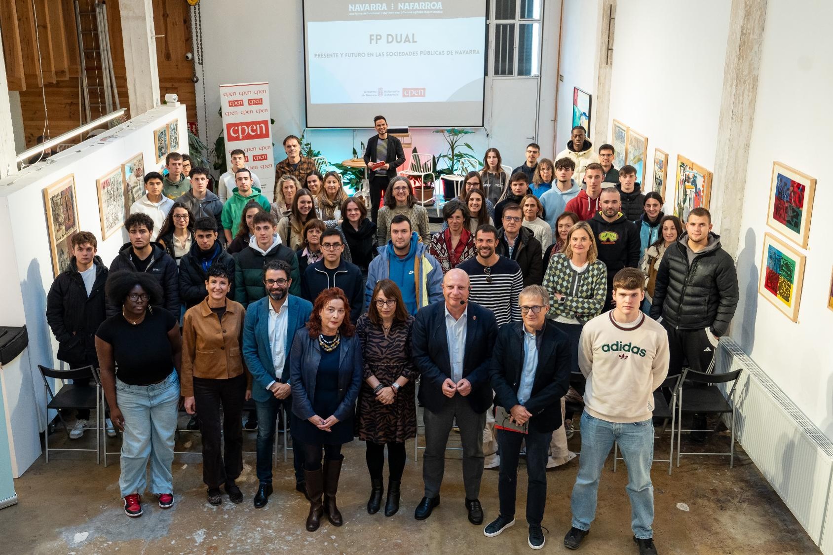 Fotografía de grupo de todas las personas asistentes al encuentro mirando a cámara, que está situada en una entreplanta superior