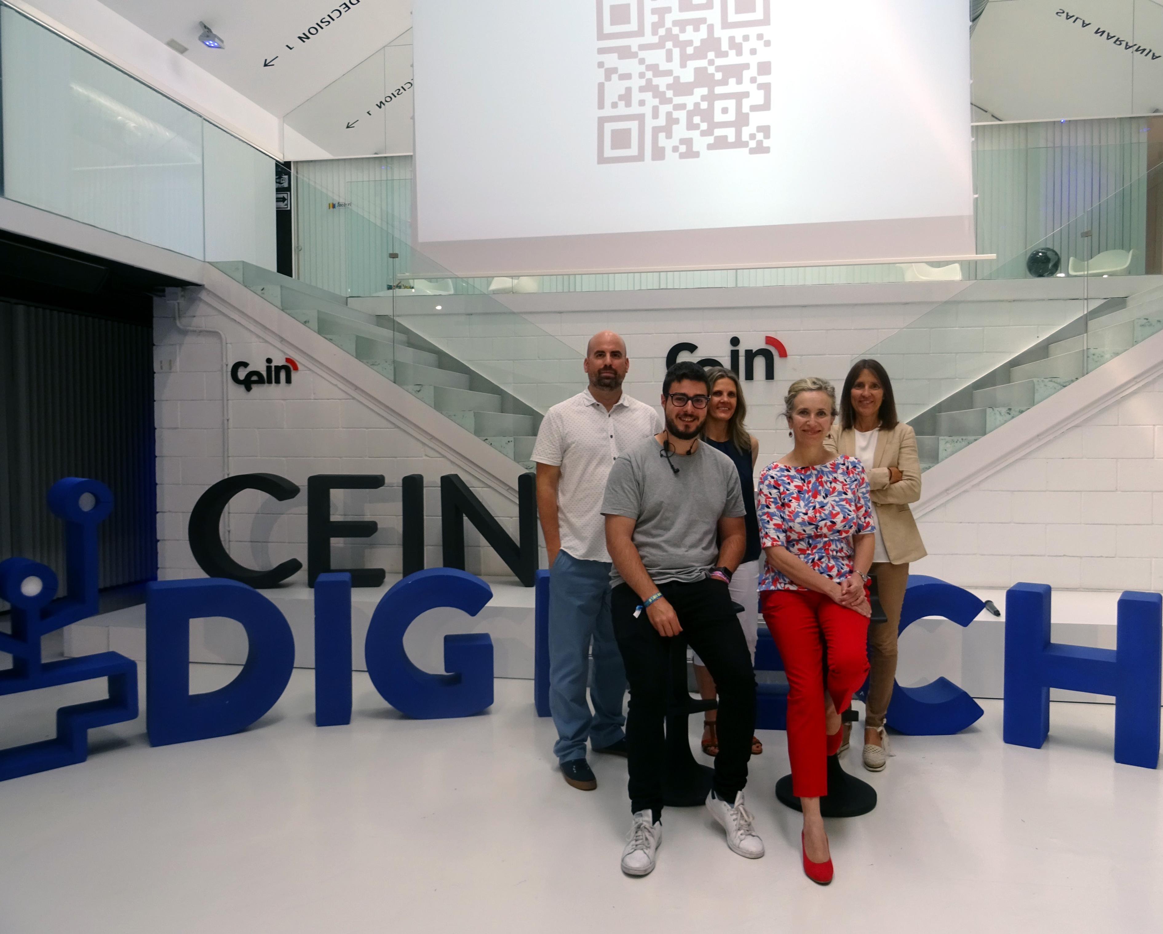 Fotografía de cinco personas de pie en la sede de CEIN