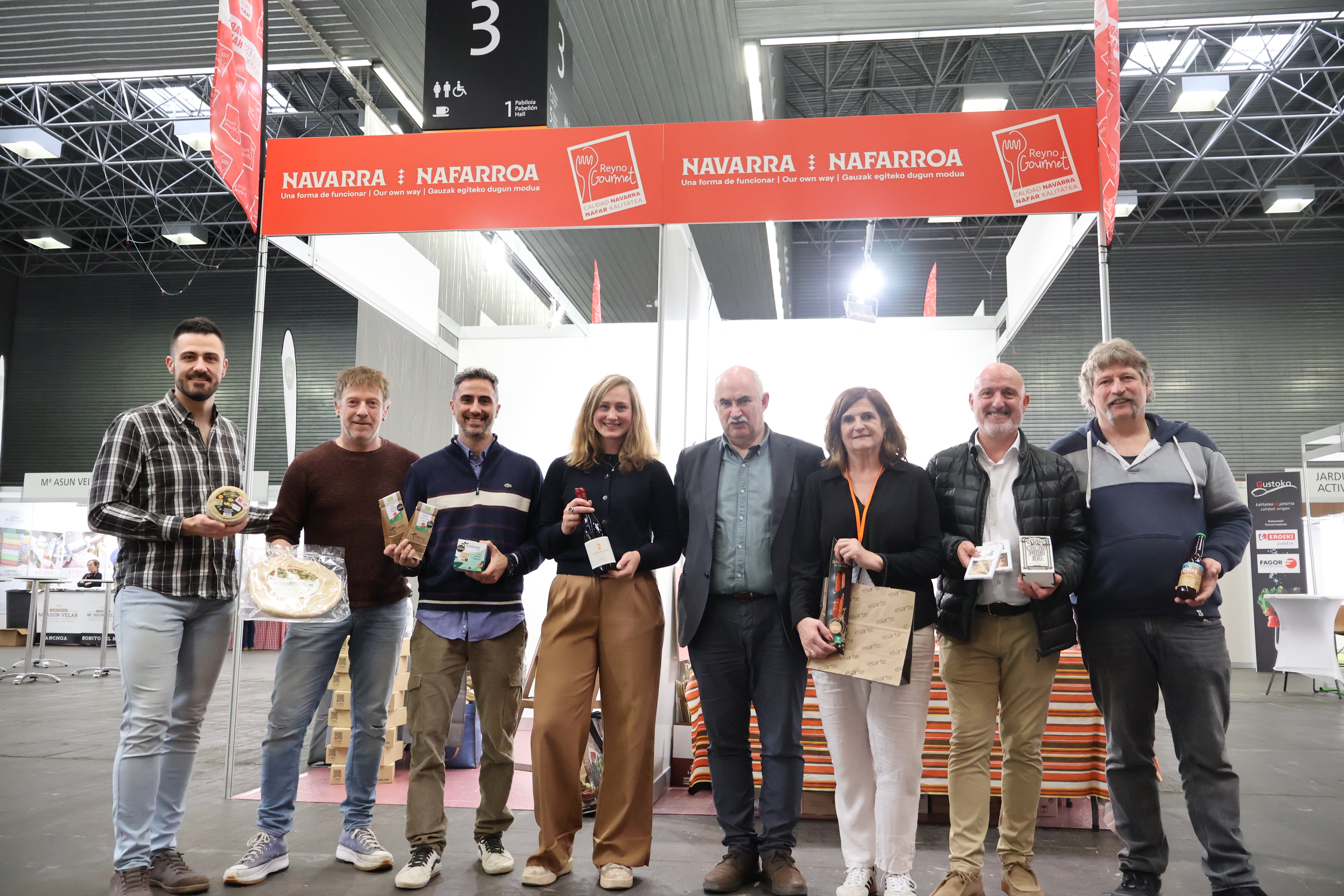 Imagen de varias personas sosteniendo productos Navarros en la feria delante del stand