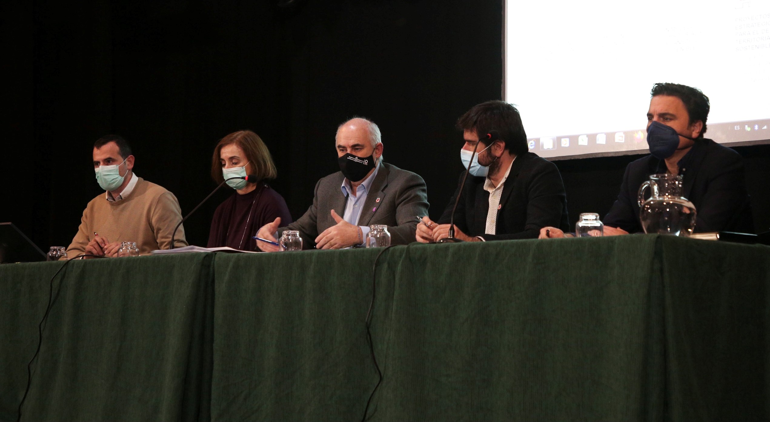 Fotografía de cuatro hombres y una mujer sentados durante la rueda de prensa.