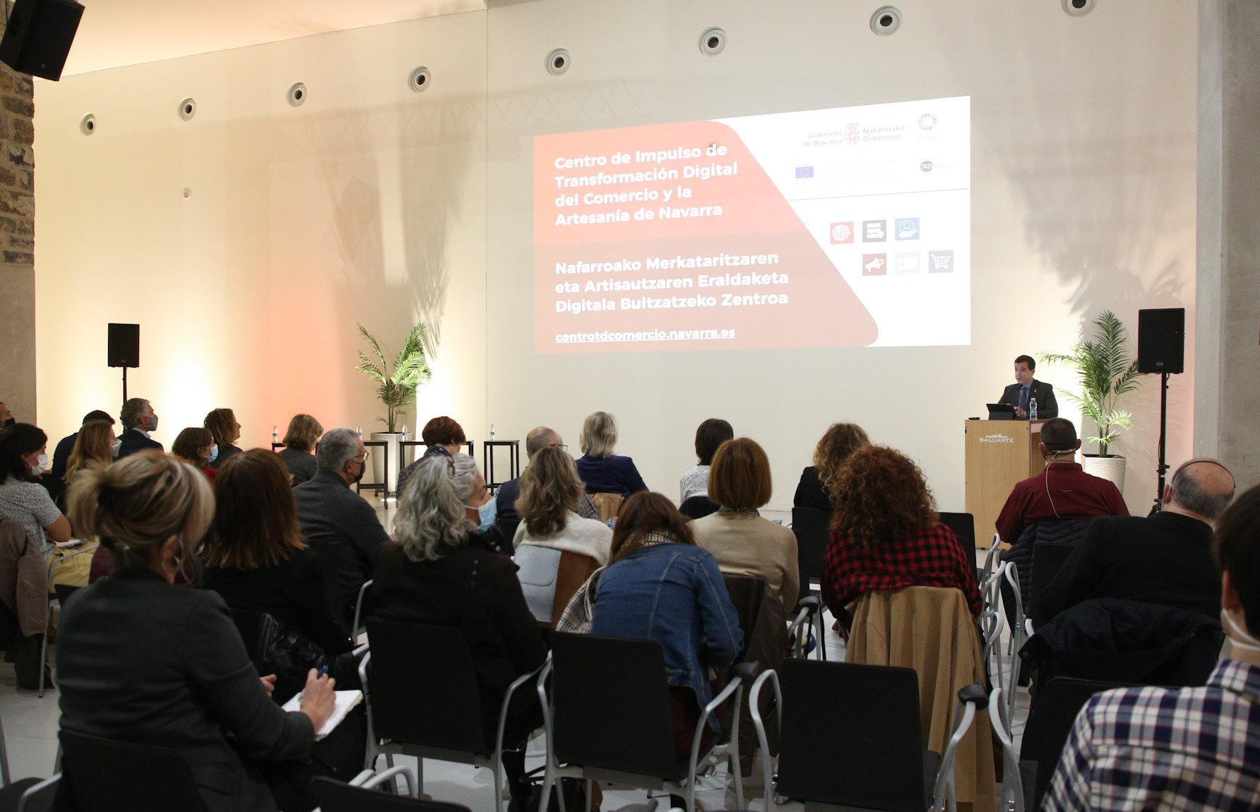 Fotografía de un instante de la presentación del proyecto con varias personas sentadas y una de pie en un atril.
