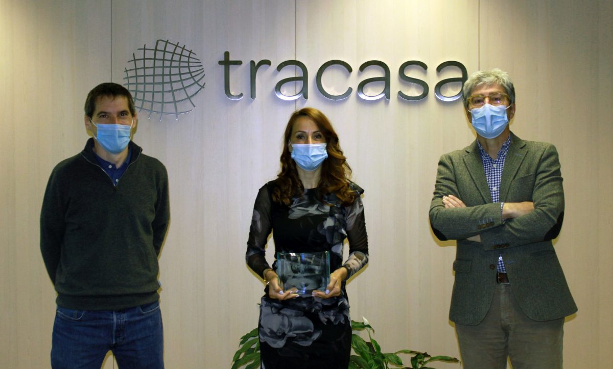 Fotografía interior de dos hombres y una mujer, ésta con el premio en la mano.