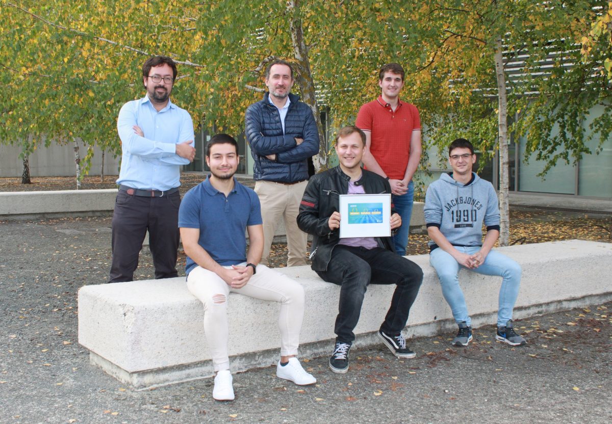 Fotografía de seis chicos sentados en un banco mostrando un diploma.