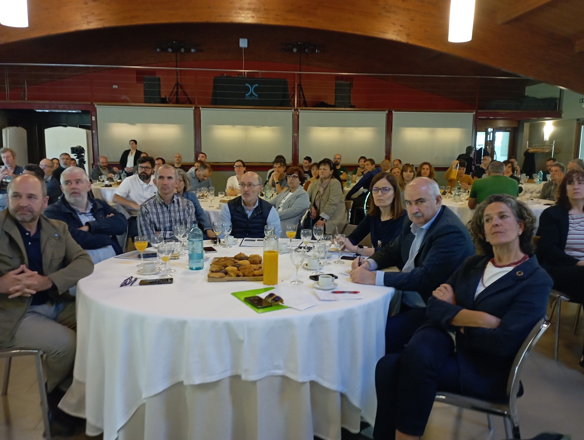 Fotografía del consejero José Mari Aierdi e Itziar Gómez, con participantes en la presentación de la memoria anual de GAN-NIK, esta mañana.