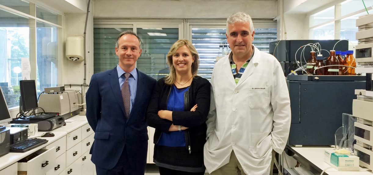 Fotografía de dos hombres y una mujer de pie en un laboratorio.
