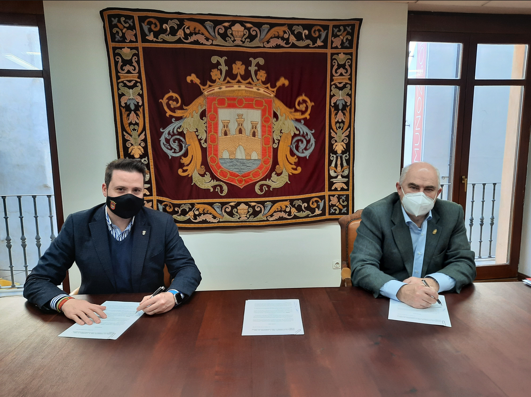 Fotografía de los dos representantes en un despacho firmando el convenio sentados en una mesa