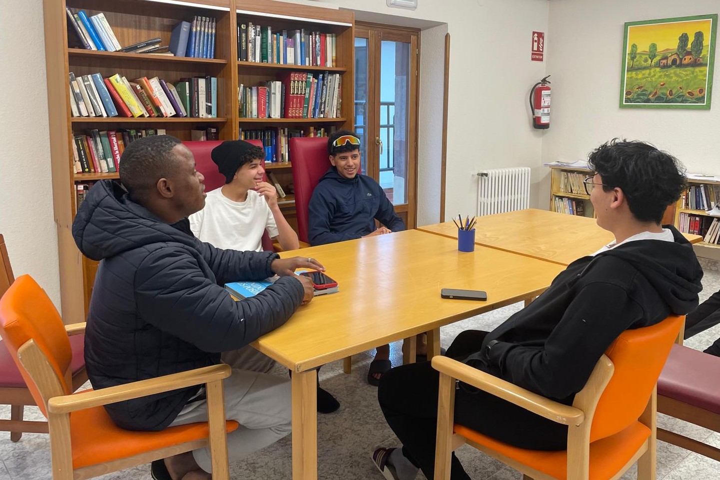 Cuatro jóvenes hablando en una mesa