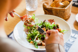 Una persona come una ensalada en un bar