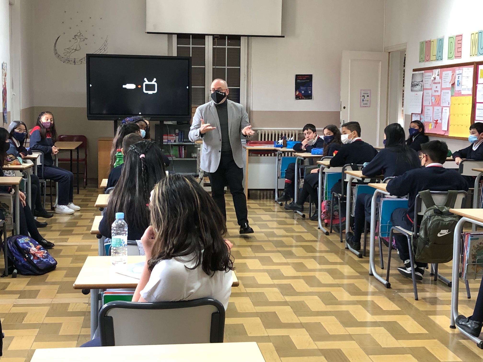 Fotografía del consejero Cigudosa en un aula con varios alumnos y alumnas