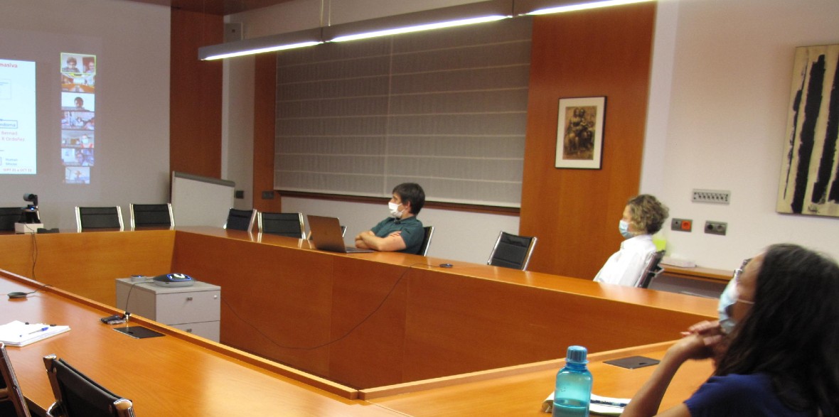 Fotografía de una sala de reuniones donde están sentadas tres personas