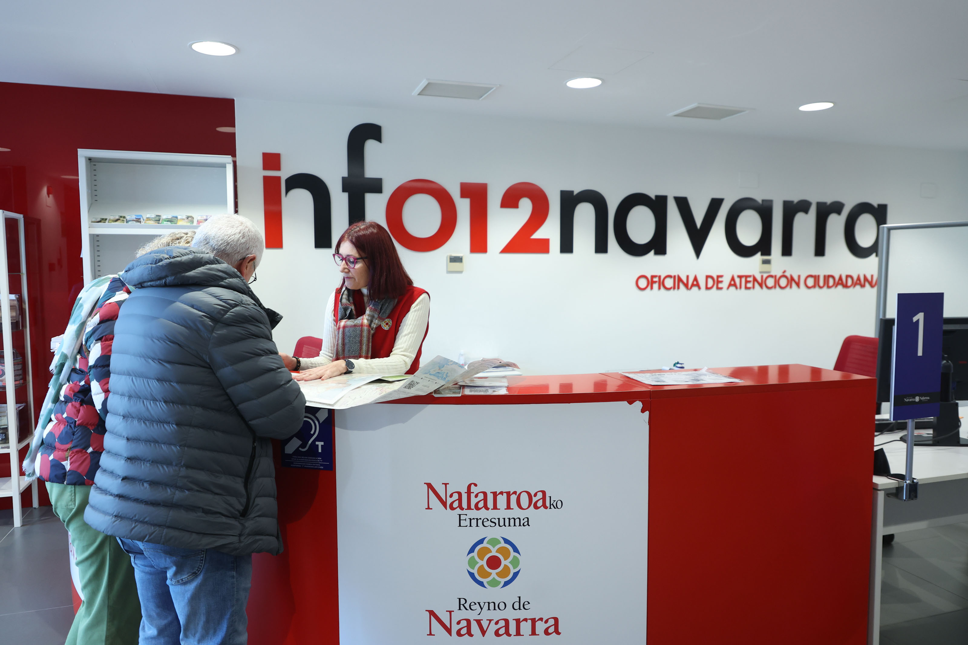 Fotografía donde aparecen una pareja de señores mayores siendo atendidos en el mostrador de la oficina de atención ciudadana de Tudela