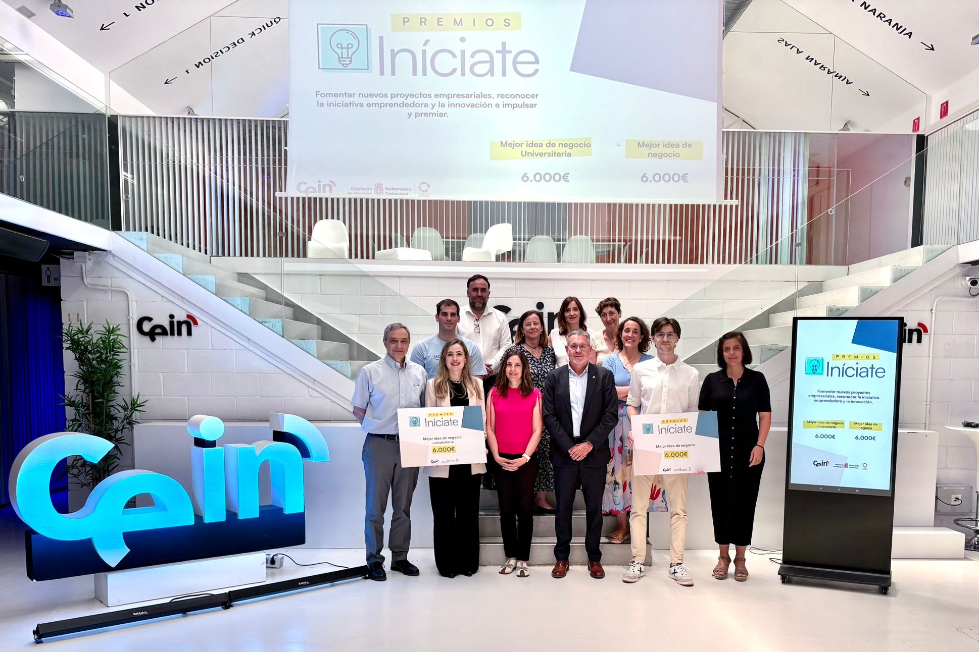 Grupo de personas posando con los carteles de los premios 