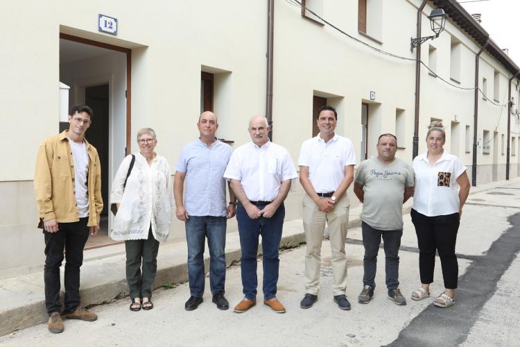 Fotografía de varias personas de pie delante de las viviendas rehabilitadas