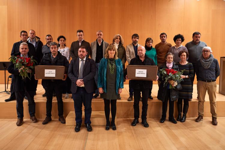 Fotografía de la consejera Ana Ollo, en el centro, junto al Presidente del Parlamento, Unai Uhalde, y familiares de Julio Butrón García y Manuel Serón Marco.  