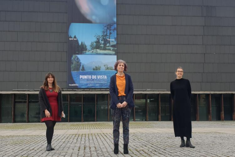 Fotografía de tres mujeres de pie con un edificio detrás.