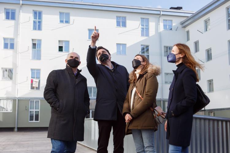 Fotografía de dos hombres y dos mujeres observando un edificio.