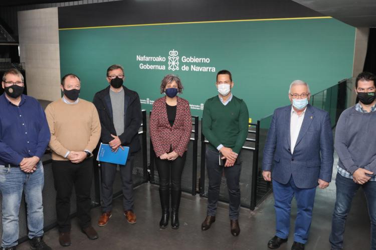 Fotografía de seis hombres y una mujer de pie dentro del pabellón Navarra Arena.