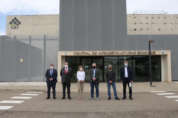 Fotografía exterior de cinco hombres y una mujer delante de un edificio