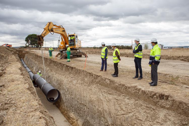 Fotografía exterior de las obras del canal donde aparecen cuatro operarios y una grúa.