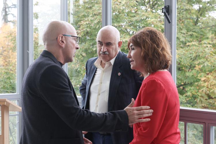 Fotografía de dos hombres y una mujer hablando durante el acto.