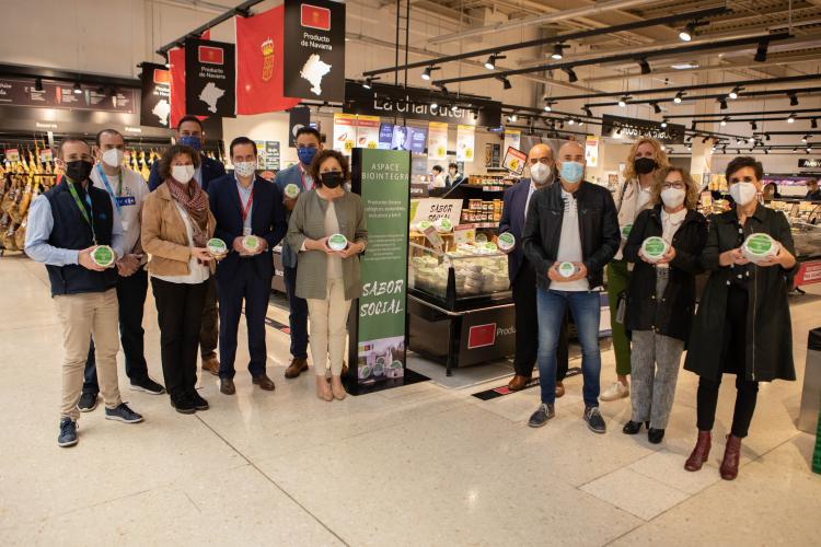 Fotografía interior de varias personas de pie con productos alimenticios