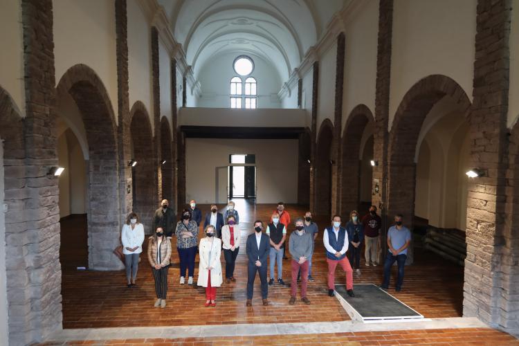 Fotografía de varias personas de pie dentro de una iglesia