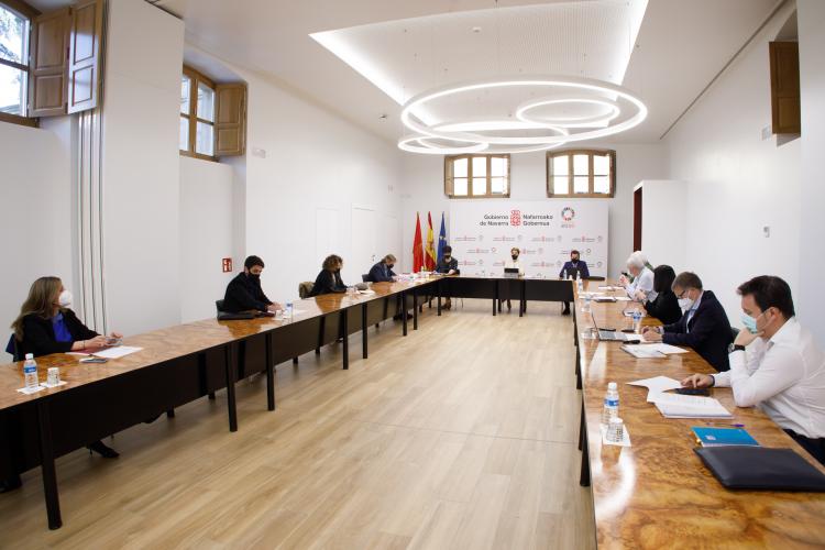 Fotografía interior de la reunión con doce personas sentadas en una mesa