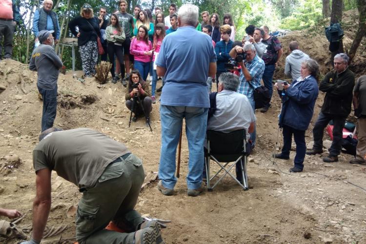 Fotografía exterior de un grupo de personas observando el lugar donde se han encontrado los restos.