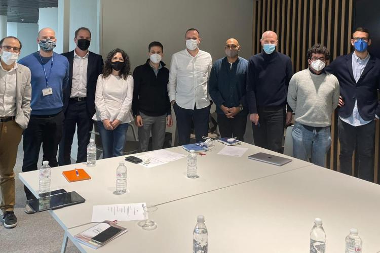 Fotografía de doce personas de pie en una sala de reuniones.
