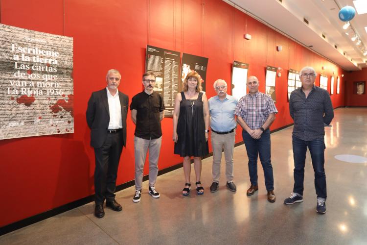 Fotografía de cinco hombres y una mujer de pie dentro del Planetario de Pamplona
