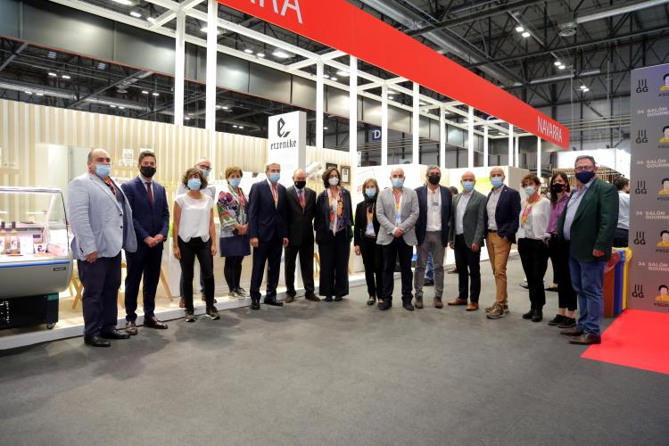 Fotografía de la consejera y las personas que exponen delante del stand. 