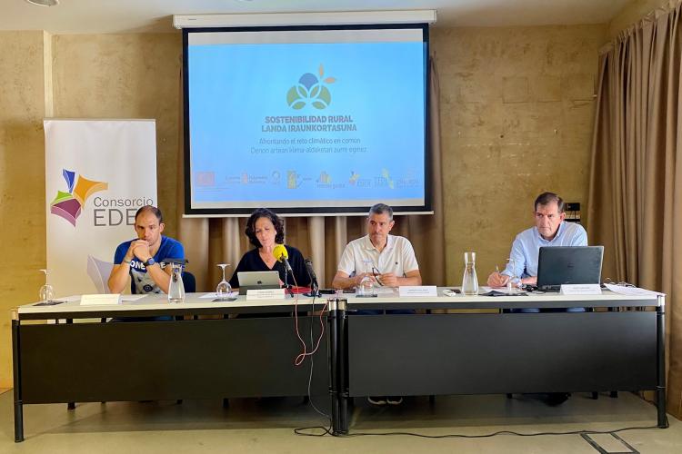 Fotografía de cuatro personas sentadas en una mesa durante la presentación