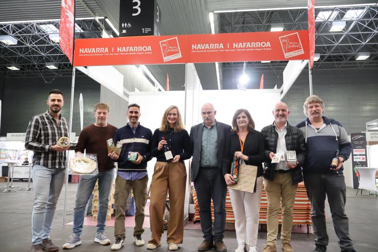 Imagen de varias personas sosteniendo productos Navarros en la feria delante del stand