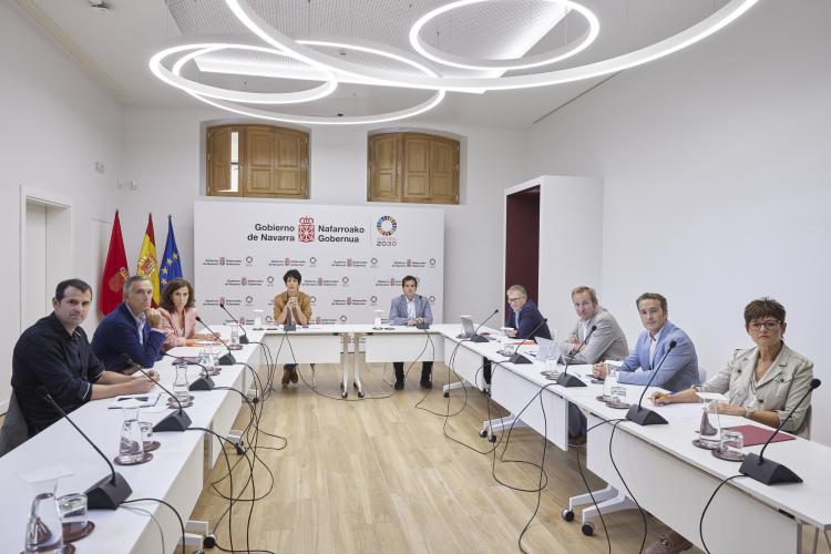 Fotografía de todos los miembros del Consejo de Administración sentados en forma de U mirando a cámara. En el fondo, Elma Saiz preside la reunión. A su lado, el consejero Mikel Irujo.