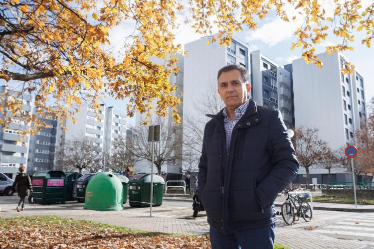 Fotografía de un hombre con varios edificios de viviendas rehabilitados detrás