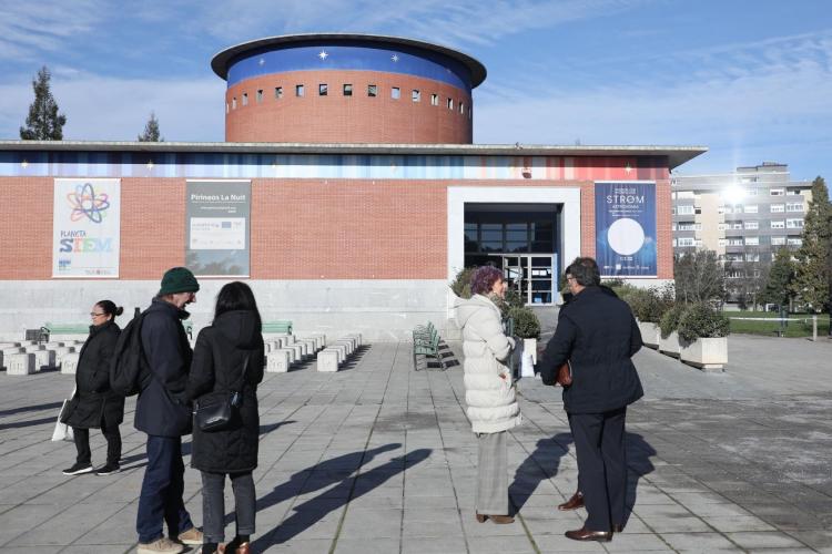 Grupo de personas conversando delante de la puerta del planetario