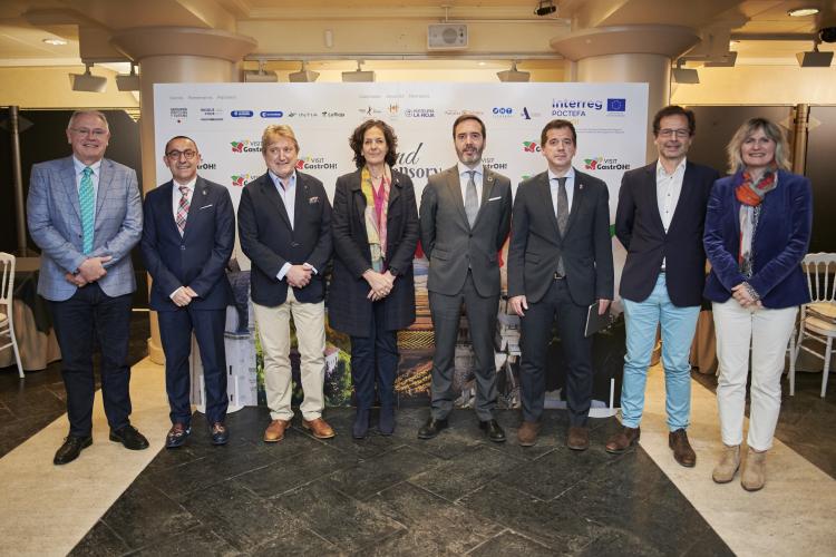 Fotografías de varias personas de pie delante del cartel promocional de la iniciativa.