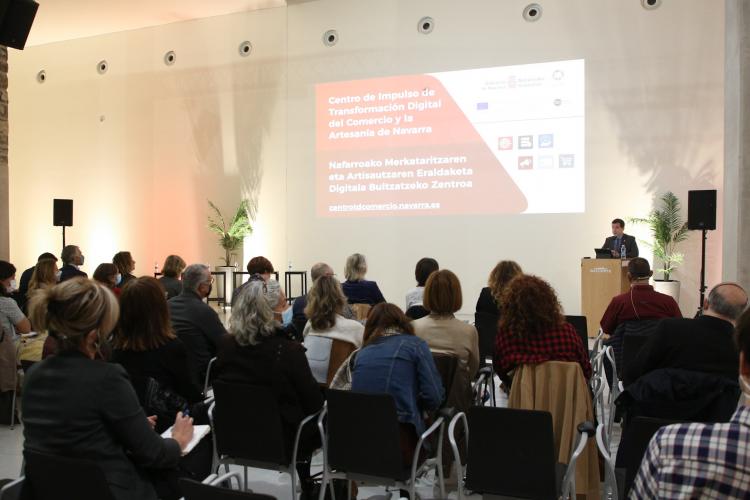 Fotografía de un instante de la presentación del proyecto con varias personas sentadas y una de pie en un atril.