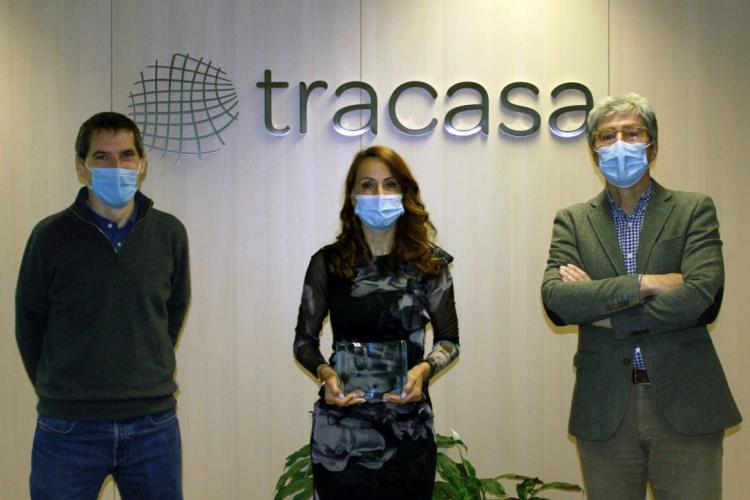 Fotografía interior de dos hombres y una mujer, ésta con el premio en la mano.