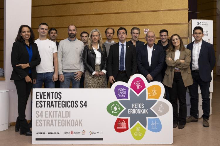 Fotografía con 13 participantes en el evento celebrado en la sede de EVENA. Mirando a cámara y con un cartel en el centro donde se lee EVENTOS ESTRATÉGICOS S4