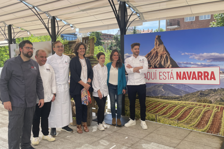 Fotografía de la consejera Gómez y Belén Huarte, con chefs participantes en el acto. 