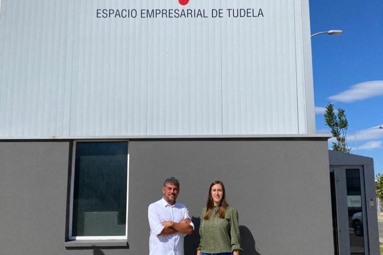 Fotografía de dos personas delante de la fábrica Nexo