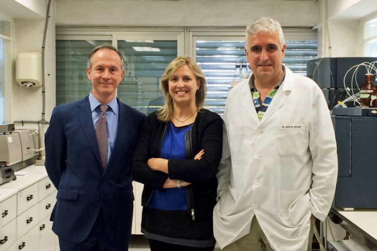 Fotografía de dos hombres y una mujer de pie en un laboratorio.